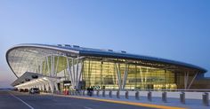 an airport terminal at dusk with people waiting to board the plane or take off from it