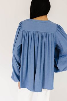 this retro-inspired long sleeve top will take you from summer picnics to fall photoshoots with ease. made with a dark wash denim-esque material, this elevated top features long balloon sleeves + a flowy silhouette. dress it up with trousers + heels, or down with white jeans + sandals. medium wash // high neckline, buttons, balloon sleeves, elastic cuffs paired with our camelot wide leg denim model is 5'8" + wearing a small measurements are approximate + taken while laying flat small : bust 42” l Billowy Cotton Long Sleeve Dresses, Billowy Long Sleeve Cotton Dress, Cotton Billowy Long Sleeve Dress, Spring Blouse With Smocked Cuffs And Relaxed Fit, Fall Peasant Top With Blouson Sleeves For Daywear, Spring Daywear Peasant Top With Relaxed Fit, Fall Denim Puff Sleeve Top, Medium Wash Long Sleeve Denim Top For Day Out, Spring Bishop Sleeve Blouse In Relaxed Fit