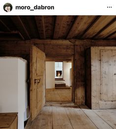 an empty room with wooden floors and doors leading to a fire place in the fireplace