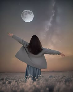 a woman is standing in the clouds with her arms spread out to reach the moon