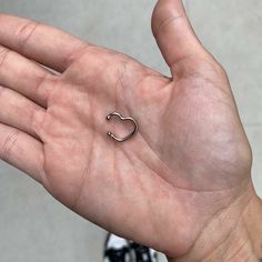 a person's hand with a small silver ring on top of their left palm