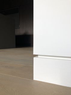 an empty room with wooden floors and white walls, is shown in the foreground