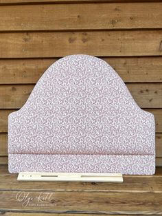 a white and pink headboard on top of a wooden bench