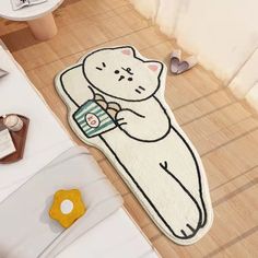 a bathroom rug with a cartoon bear holding a cup on the floor next to a toilet