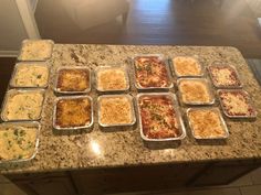 many trays of food are sitting on the counter top, ready to be served