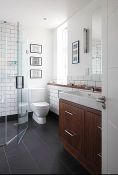 a bathroom with a toilet, sink, and shower stall is shown in this image