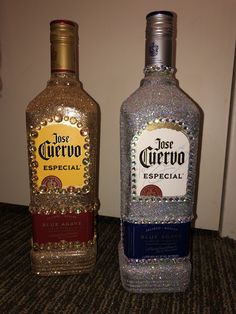 two bottles of liquor sitting on top of a carpeted floor next to each other