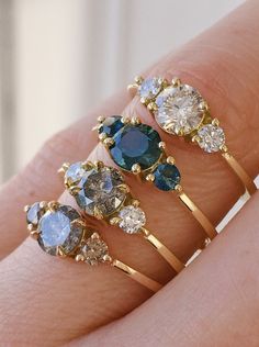 A selection of four dainty trilogy rings with different coloured gemstones and salt and pepper diamonds. Multistone Rings Engagement, Rings Swarovski, Colored Stone Engagement Rings, 3 Stone Engagement Rings, Colored Engagement Rings, Ring Ideas, Mom Jewelry