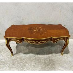 an antique coffee table with gold trimmings on the top and bottom, inlaid to