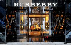 a burberry store front with an advertisement on the door and lights in the windows