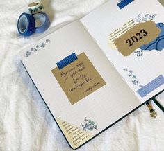 an open notebook with the year 2013 on it next to a cup of coffee and a pair of scissors