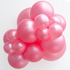 a bunch of pink balloons floating on top of each other in front of a white background