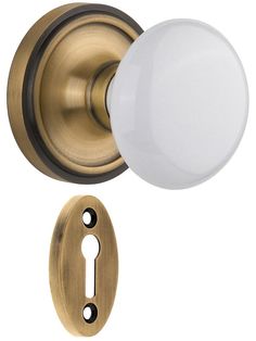 an antique brass door knob with a white glass ball on the front and back of it