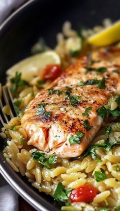 a close up of a plate of food with fish and rice on it, next to a fork