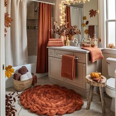 a bathroom decorated in fall colors with pumpkins and leaves