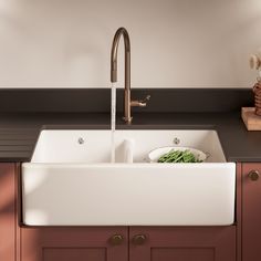 a white sink sitting under a faucet in a kitchen