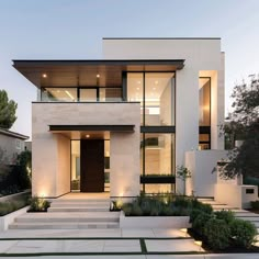 a modern house with large windows and steps leading up to the front door