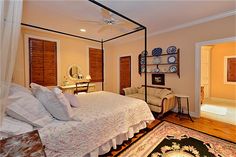 a bedroom with a canopy bed and wooden shutters