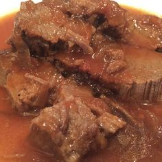 a close up of some food on a plate with broth and meat in it