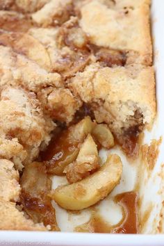 a close up of a pie with apples on it in a white casserole dish