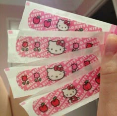 hello kitty nail stickers are being held up