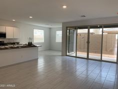 an empty kitchen and living room with sliding glass doors