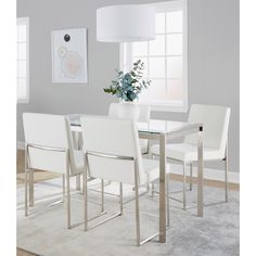 a dining room table with white chairs and a vase filled with flowers on top of it