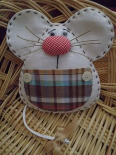 a mouse made out of fabric sitting on top of a wicker basket