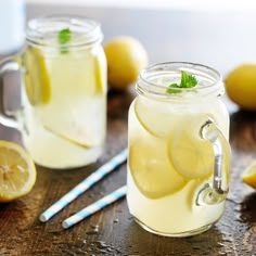 a jar filled with lemonade and water next to sliced lemons