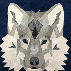 a quilted wolf head with blue eyes