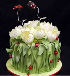 a cake decorated with white flowers and ladybugs