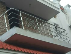 a balcony with metal railings and red tile on the side of a brick building