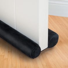 the corner of a room with a black and white floor mat on top of it