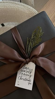 a present wrapped in brown ribbon with a tag on it