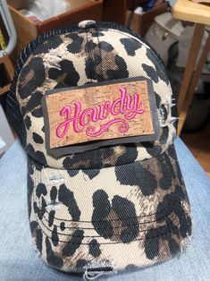 "Time to Cowgirl Up and let them know you're ready to play! Leopard print distressed trucker hat. Elastic criss-cross, ponytail back.  \"Howdy\" embroidered on faux leather  (Distressing may vary on cap and patch due to manufacturing processes)" Trendy Distressed Adjustable Trucker Hat, Trendy Distressed Snapback Trucker Hat, Trendy Adjustable Distressed Trucker Hat, Trendy Distressed Trucker Hat, Cowgirl Up, Adjustable Distressed Brown Trucker Hat, Distressed Brown Baseball Cap One Size, Patched Trucker Hat, Distressed Brown Trucker Baseball Cap