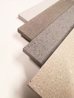 three different colored concrete blocks sitting on top of each other, one is white and the other is gray