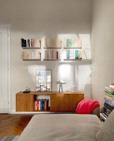 a bedroom with a bed, bookshelf and lamp on the wall above it