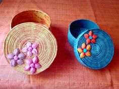 two baskets sitting on top of a table with flowers in them and one is made out of straw