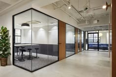 an office with glass partitions and plants in the center, along with potted plants