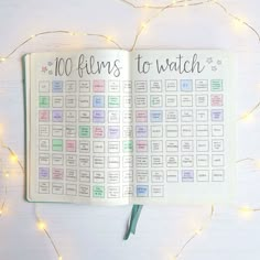 an open planner with the words 100 films to watch written on it