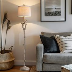 a living room with a couch, lamp and pictures hanging on the wall above it