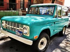 an old blue truck is parked on the street