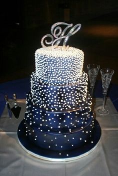 a three tiered cake with white stars on it and the number twenty six on top