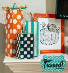 three small boxes are sitting on top of a mantel, decorated with pumpkins and polka dots