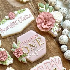 cookies decorated with pink and white frosting sitting on top of a wooden table next to eggs