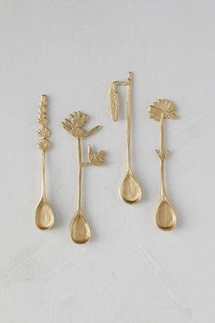 three gold spoons with flowers and leaves on them