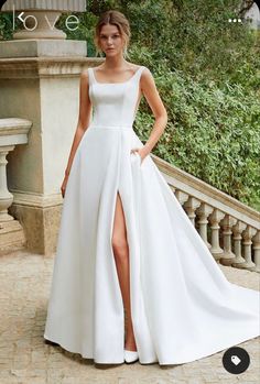 a woman in a white wedding dress posing for the camera