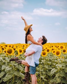 a man holding a woman on his back in a field of sunflowers