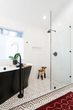 a black and white bathroom with a red rug