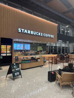 people are sitting in chairs at the starbucks coffee shop and waiting for their bags to be picked up